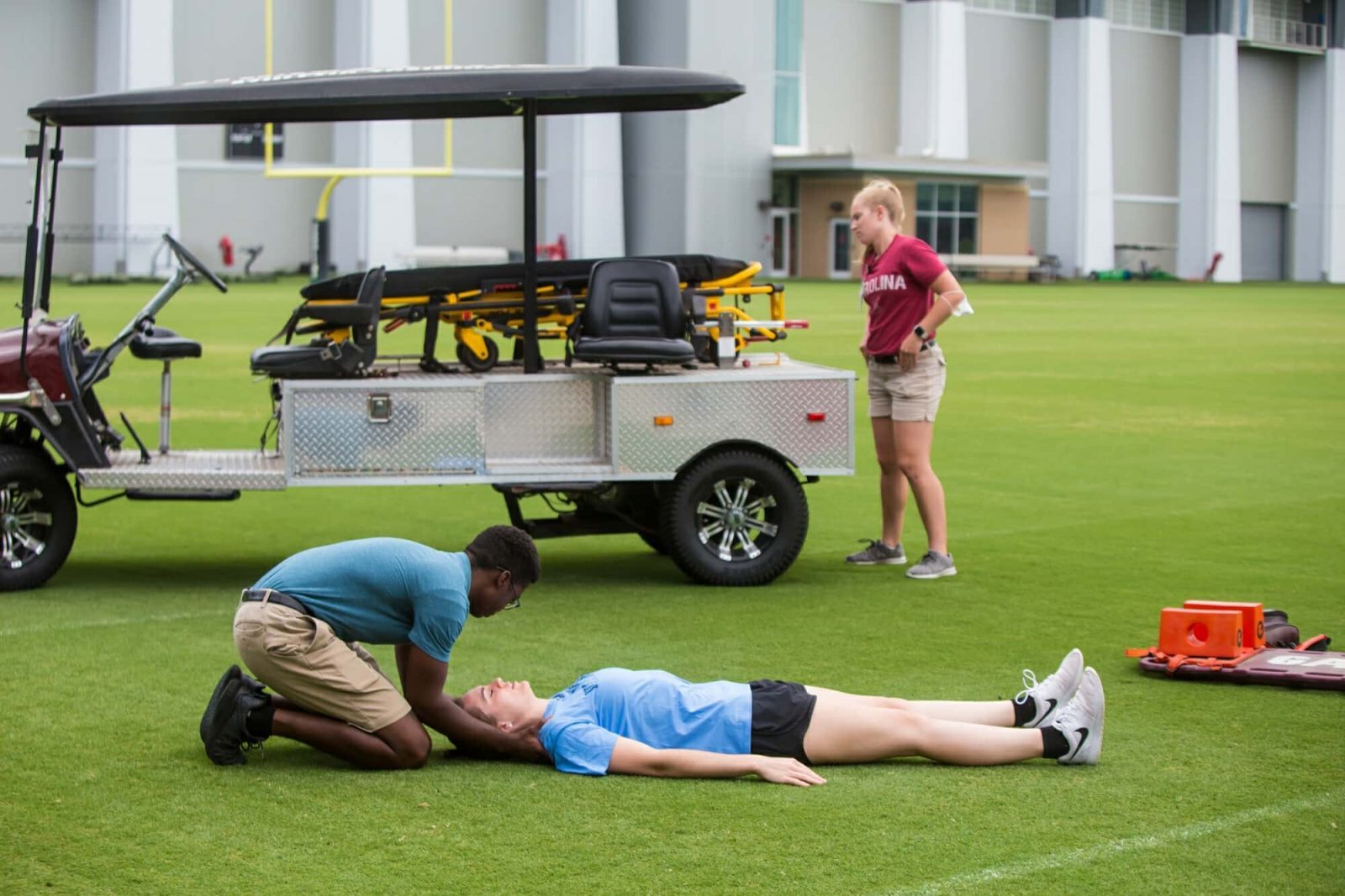 Athletic Trainer On the Field With Injured Athlete