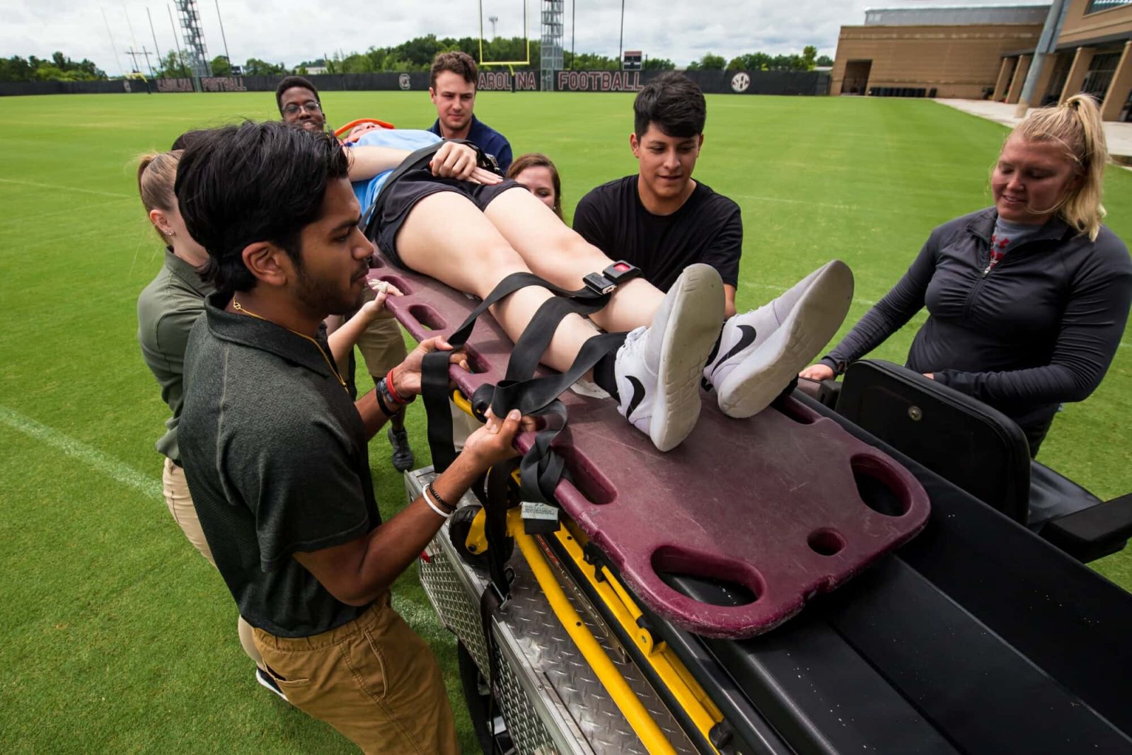 Injured Athlete With Trainers Practice