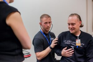 Athletic training student providing hands-on patient care instruction